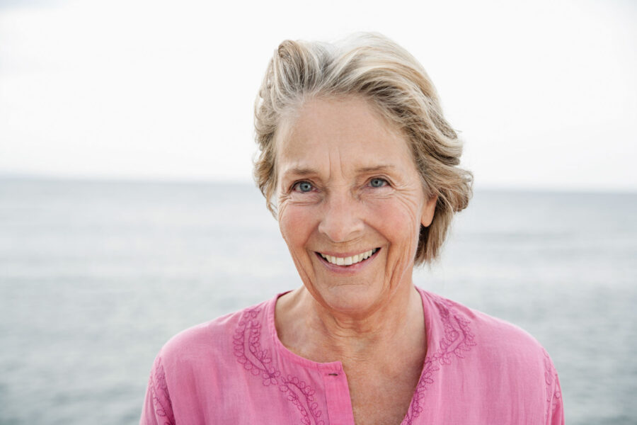 Spain, Senior woman smiling at Atlantic ocean