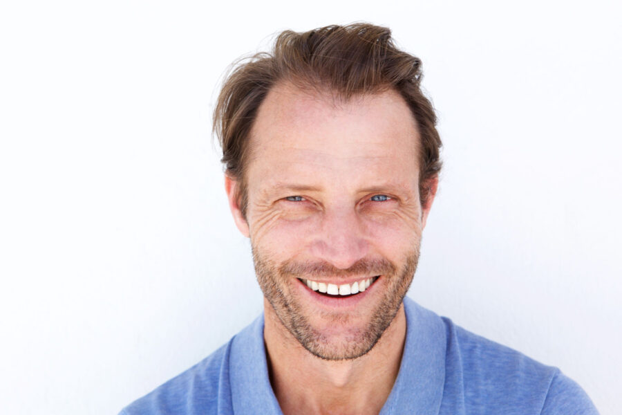 Close up happy older man smiling against white background